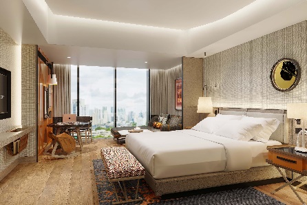 A bedroom with a large bed and a desk

Description automatically generated
