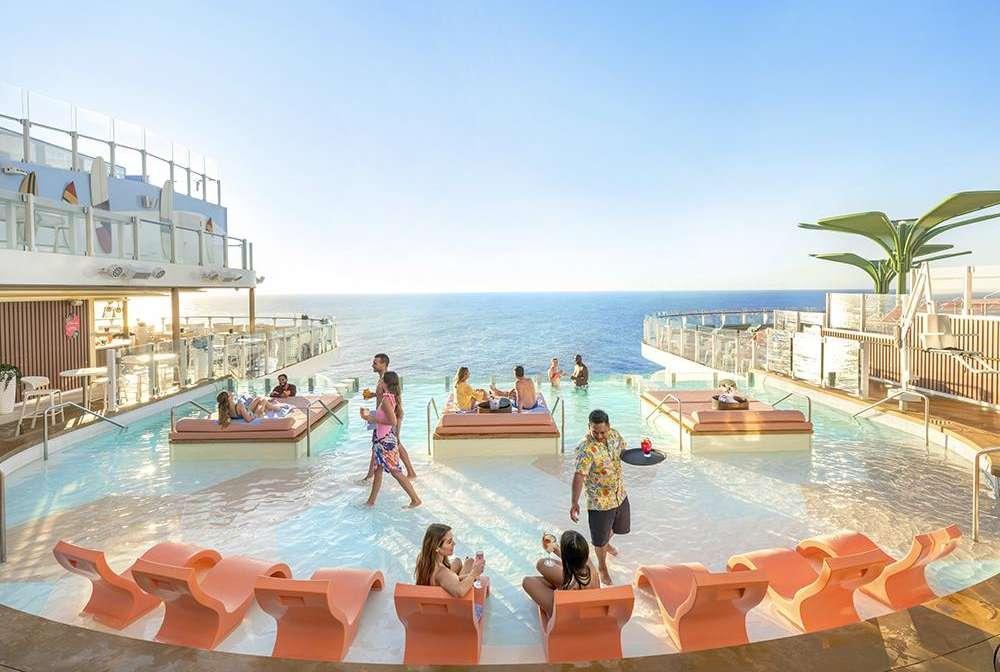 A group of people in a pool with chairs and tables on a sunny day

Description automatically generated