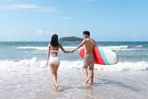A person and person holding hands and walking on the beach

Description automatically generated