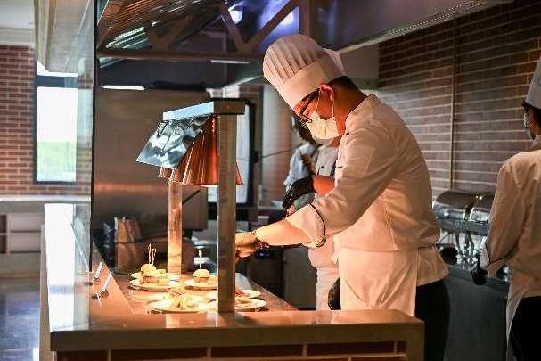 A chef cooking food in a kitchen Description automatically generated