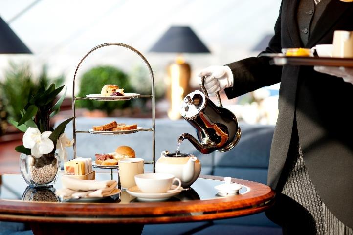 A person pouring tea into a teapot

Description automatically generated