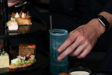 A hand holding a drink Description automatically generated